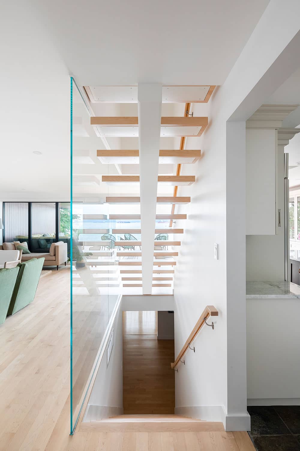 renovated staircase with glass wall and metal stringer stairs with wood caps