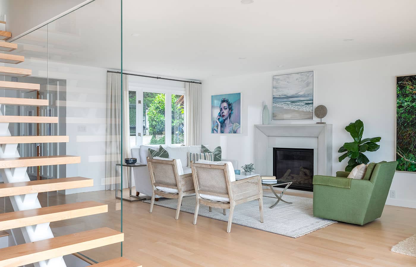 photograph of a renovated modern living room with artwork from Kelly Grace and Gordon Smith around the updated gas fireplace